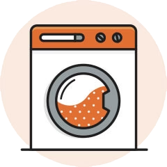 Illustration of a washing machine with an orange top and polka dot clothes inside.