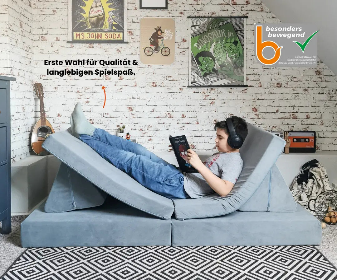 Kind liest auf Spielsofa #farbe_mond-grau